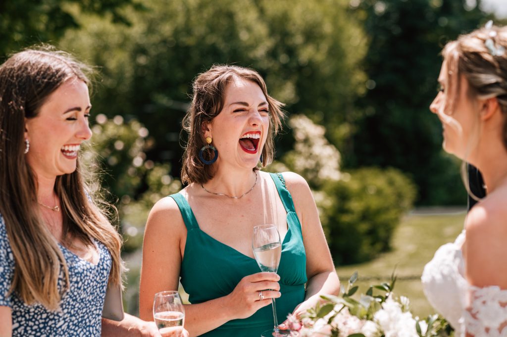 Fun Wedding Photography. Guest laughing with bride at Tewkesbury Park Hotel