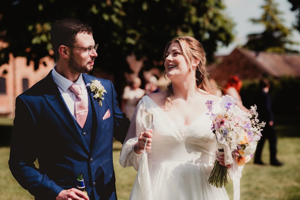 Candid moment of the couple laughing by the lake at Barns and Yard, a rustic Cotswolds wedding venue
