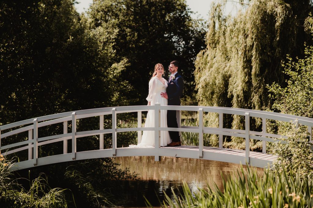 Romantic couple portrait beside the water at Barns and Yard wedding venue in the Cotswolds
