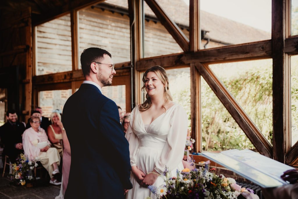 Bride and groom exchanging vows inside the beautifully restored barn at Barns and Yard Upton upon Severn