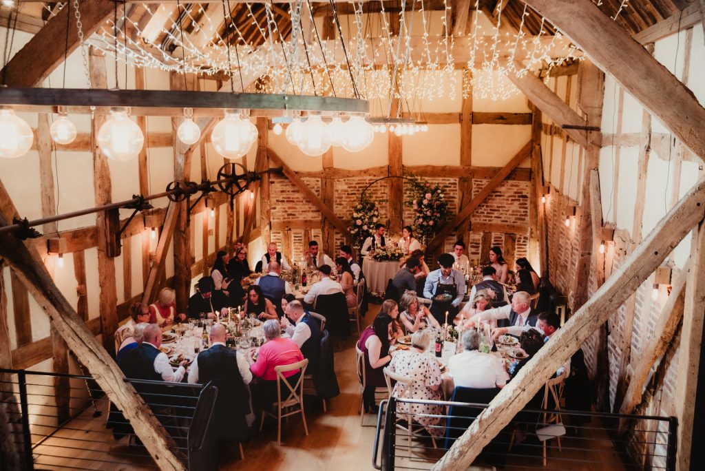The barn at Barns and Yard turned around for the wedding breakfast with pastel styling and foliage