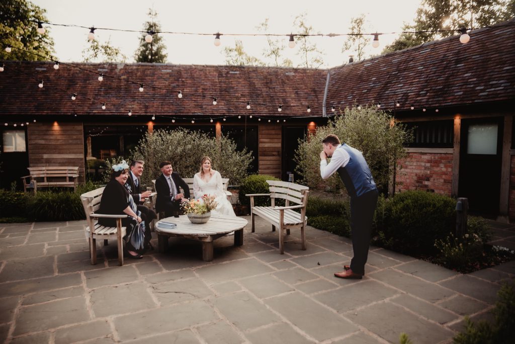 Wedding guests mingling in the courtyard during a relaxed Cotswolds barn wedding