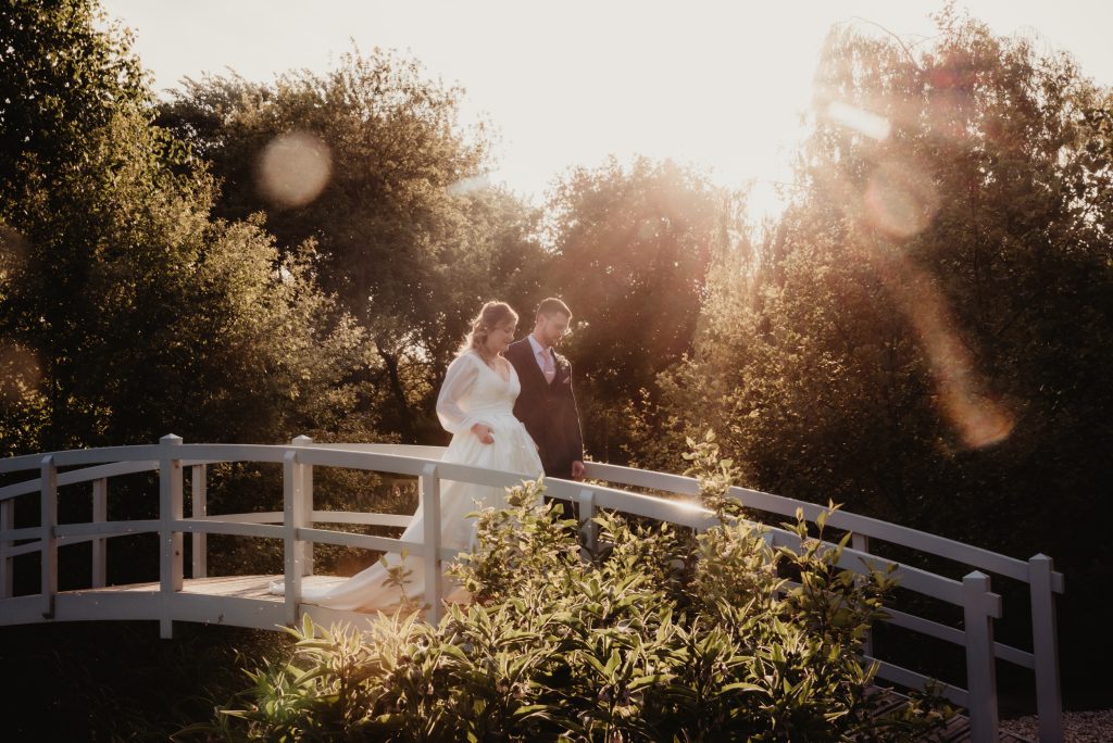 Romantic sunset portrait of bride and groom by the lake at Barns and Yard