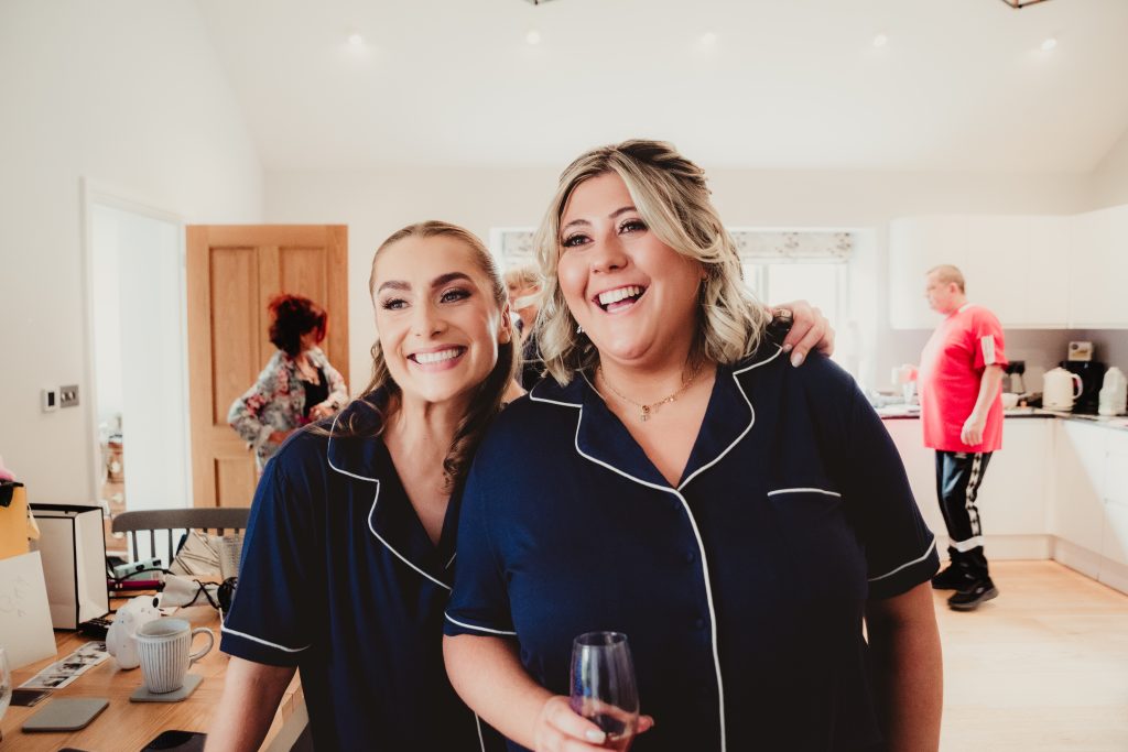 bridesmaids and a glass of Prosecco in the Hen House, candid moment by Cotswold wedding photographer