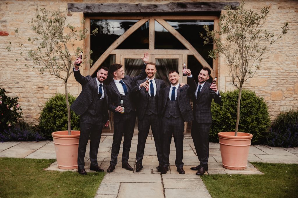 Groom and groomsmen relaxing with garden games and beers before the ceremony, photographed at Upcote Barn