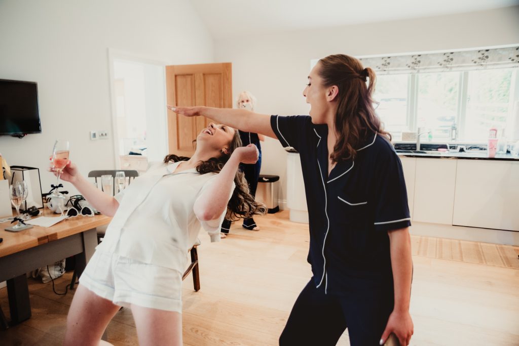 Natural fun during bridal prep with a spontaneous game of limbo, by Upcote Barn wedding photographe