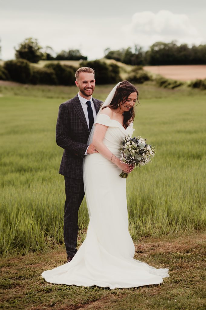 Bride and groom laughing during their relaxed wedding ceremony, photographed by a Cotswold wedding photographer