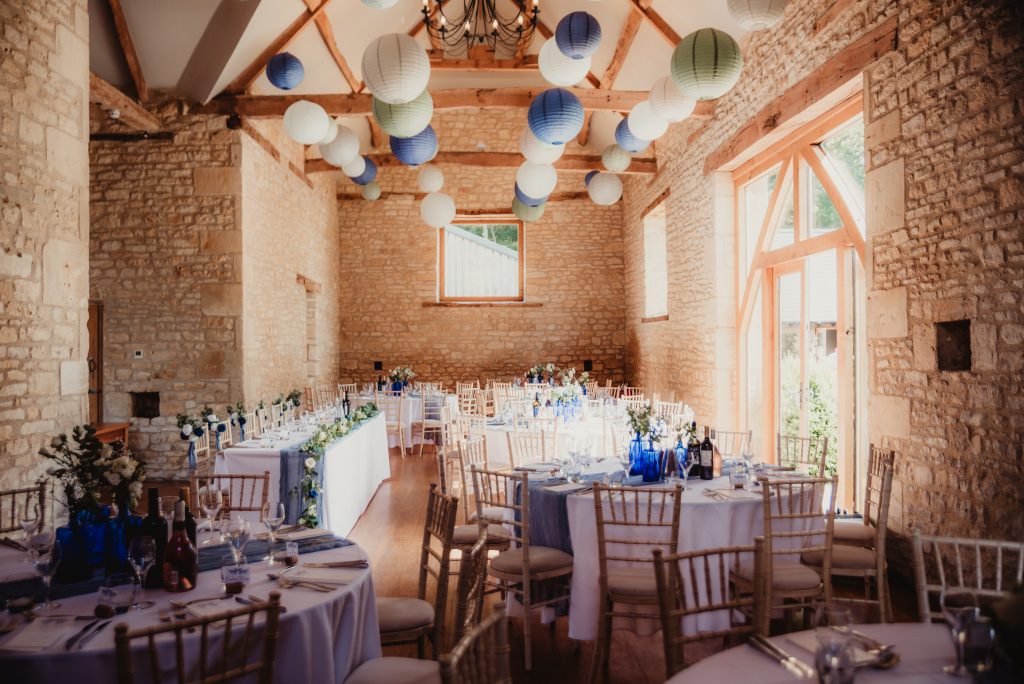 Table decor featuring vintage gin bottles and wildflowers at a Upcote barn wedding