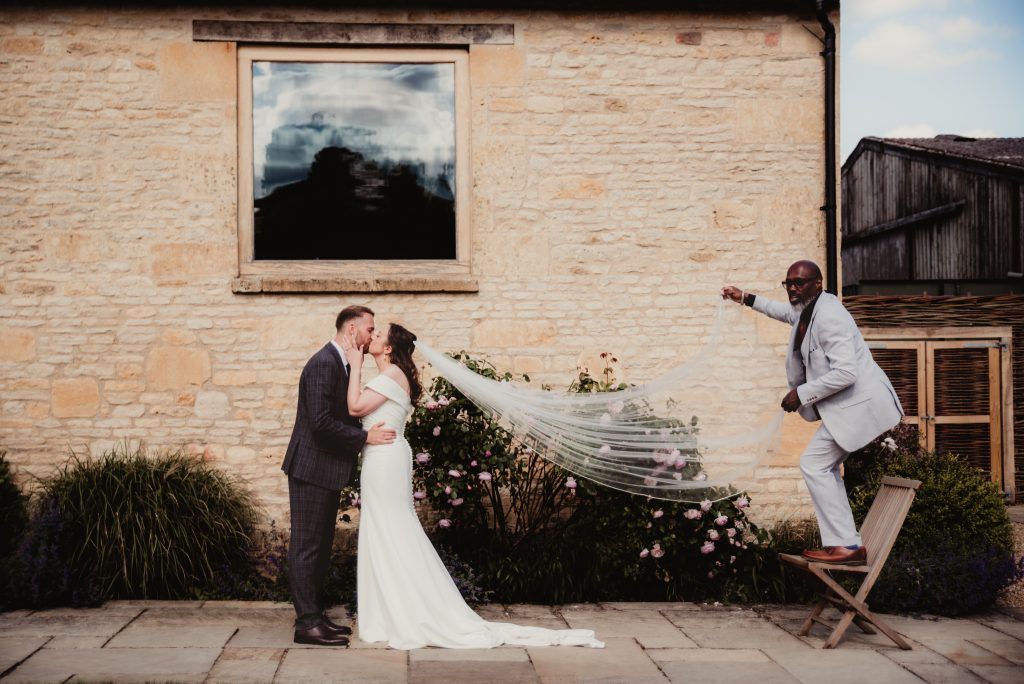 bride and grrom and guest during a veil shot