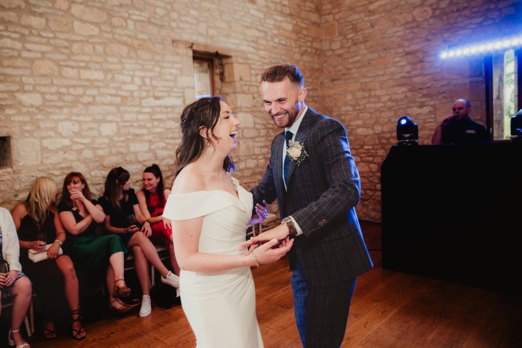 first dance fun inside the barn, captured by Gloucestershire wedding photographer